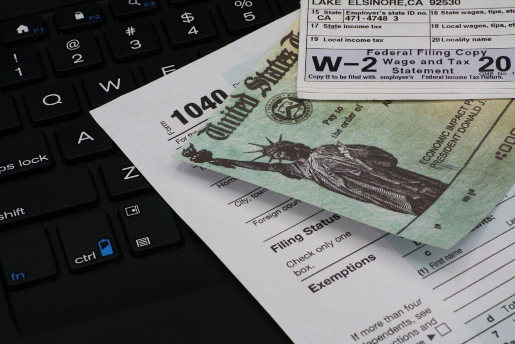 A collection of tax forms prominently featuring multiple W 2 forms stacked together for filing purposes