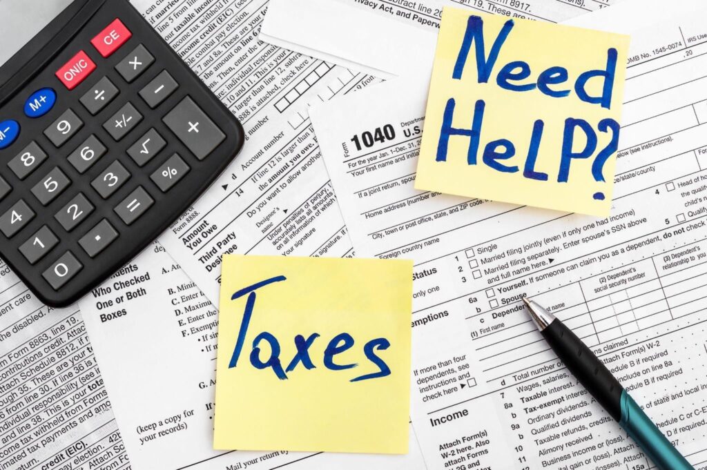 A desk scene with a calculator pen and paper represents calculating taxes