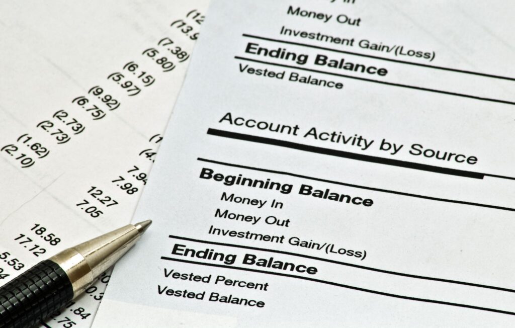 Financial account statement showing account activity and ending balance with a pen alongside.